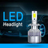 A pair of silver COB LED headlight bulbs with yellow light visible against a dark car background.