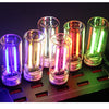 A collection of five glass accent LED night lights are displayed on a black charging station.