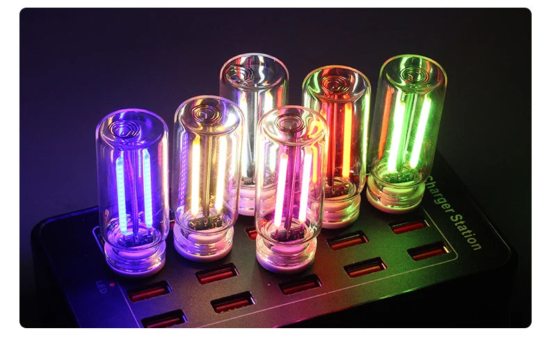 A collection of five glass accent LED night lights are displayed on a black charging station.