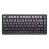A close-up view of a dark gray mechanical keyboard with purple accents and a rotary knob on the right side.