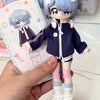 A hand holds an articulated BJD collectible figurine with light blue hair and a dark blue outfit.