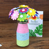 A colorful DIY flower bouquet craft kit featuring felt and buttons arranged in a glass jar.