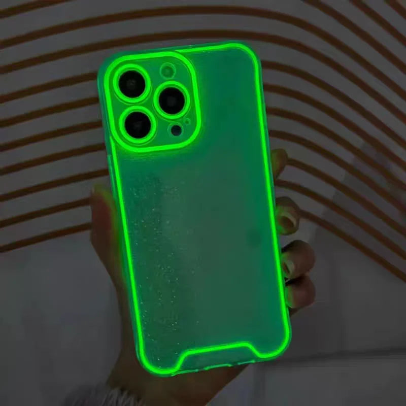 A hand holds a glow-in-the-dark neon green clear phone case for an iPhone, showing the camera module.