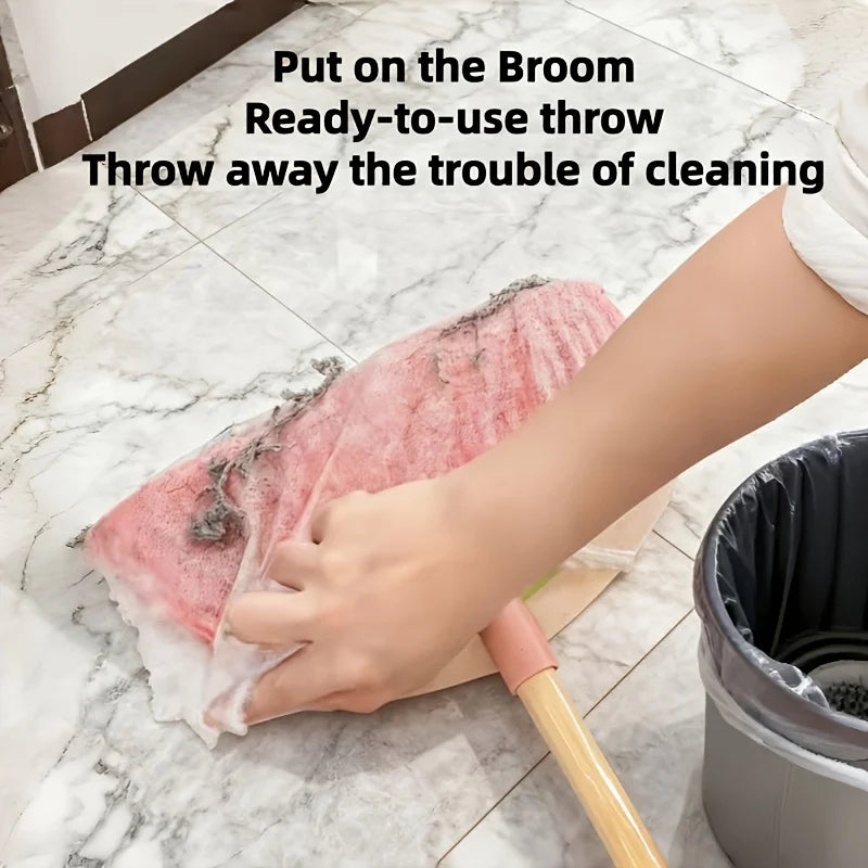 A hand is using a pink disposable broom cover to clean a marble floor.