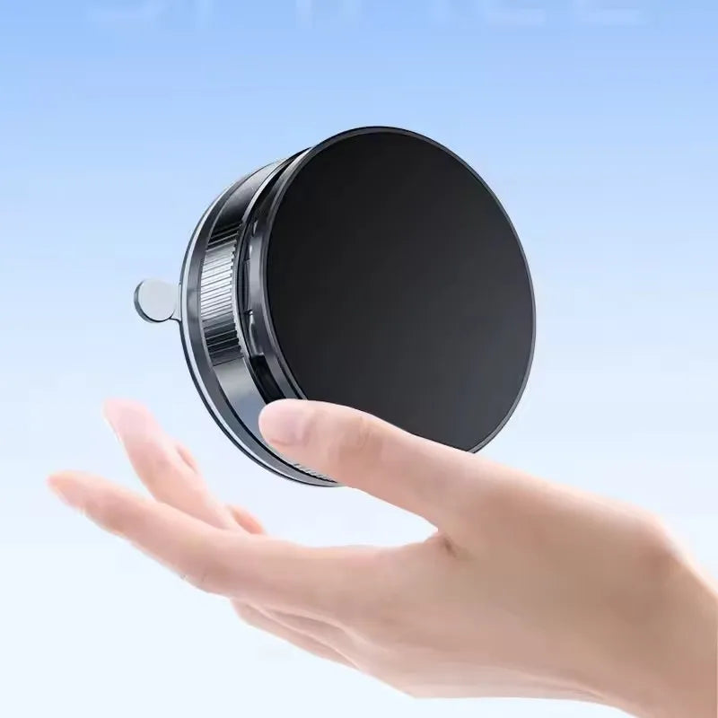 A hand is holding a black 360° rotating magnetic car phone holder device.