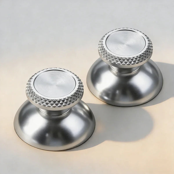 Silver aluminum thumbstick grips for a PS5 controller shown in a studio setting.