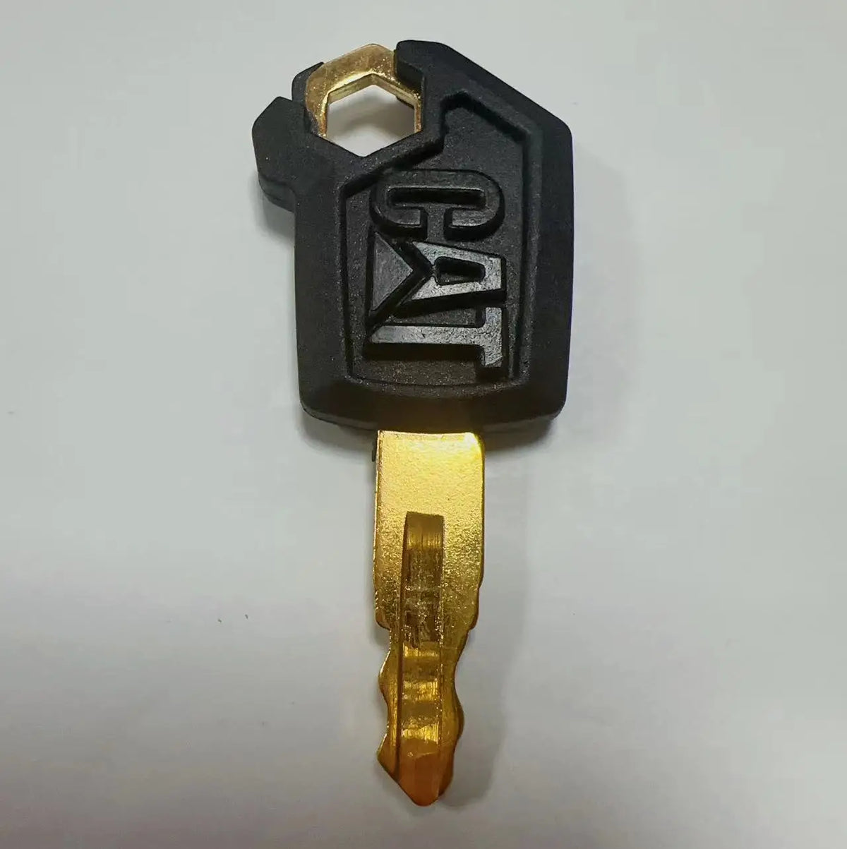 A black ignition key set for Caterpillar excavators with a brass key blade.