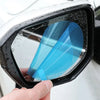 A hand holds a clear anti-fog and rain-repellent film applied to a car mirror.