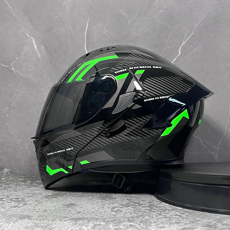 A black modular flip-up motorcycle helmet with bright green accents is displayed against a gray background.