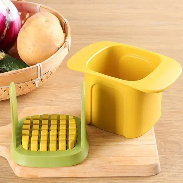 Un cortador y rebanador de vegetales amarillo de múltiples cuchillas junto a una tabla de cortar de madera con patatas y un p