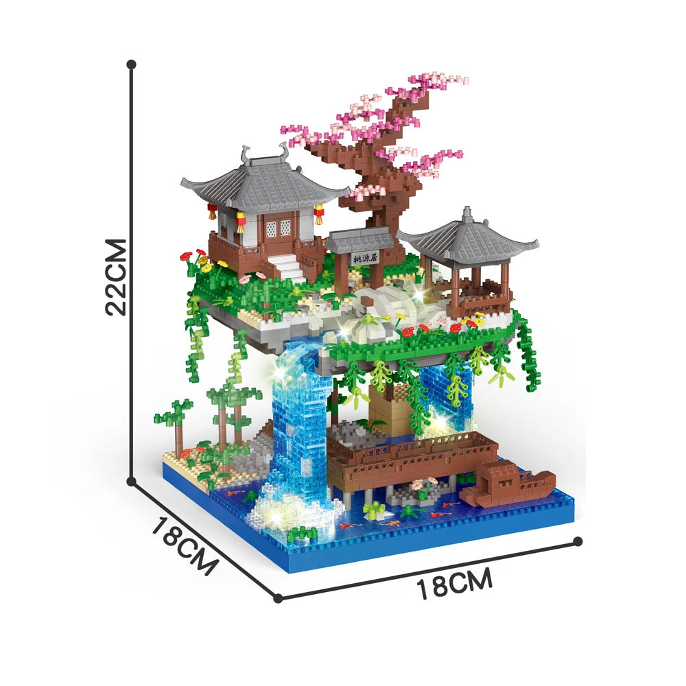 A miniature building block set depicting a traditional Japanese treehouse with a pagoda, lush greenery, and a flowing water f