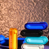 A collection of clear and colored metal fidget sliders, including blue, black, orange, and light blue variants.
