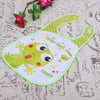 A white wipeable baby bib with a green border and a yellow frog design on the fabric