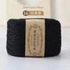 A dark black spool of bamboo fiber yarn labeled for knitting and crochet projects.