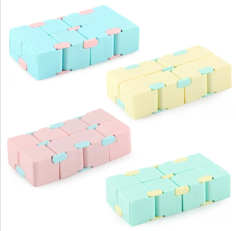 A set of colorful Infinity Magic Cube fidget toys in light blue, yellow, and pink shades.