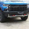 Close-up of a blue Chevrolet Silverado front grille and bumper with an aftermarket black tow hook cover.