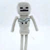 A soft plush doll resembling the Minecraft character Steve with a gray body and black facial features.