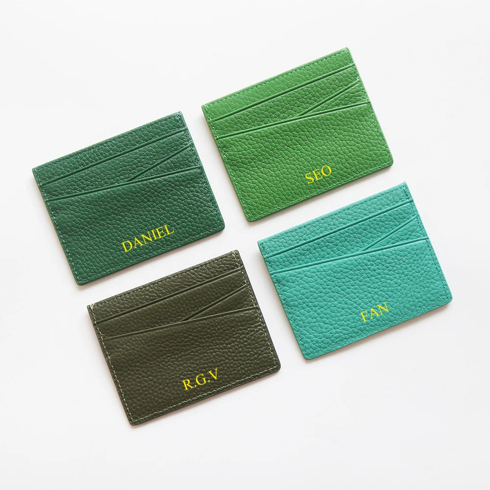 Three genuine leather slim card holder wallets in shades of green and olive, labeled Daniel, SEO, and R.G.V.