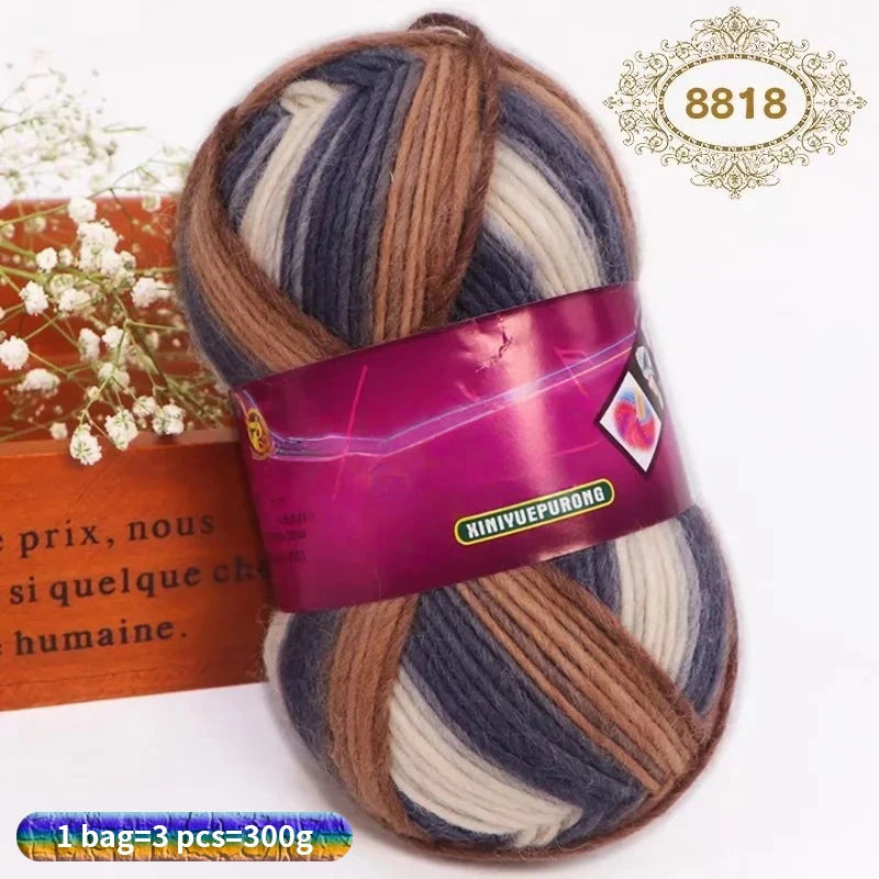 A ball of gradient dyed wool blend yarn with purple and blue stripes is shown on a white background.