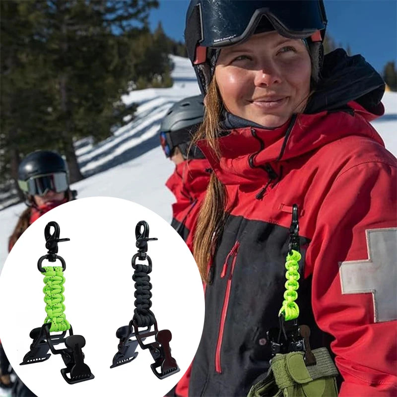 A person wearing a red jacket is holding a green braided paracord work glove clip with a carabiner.