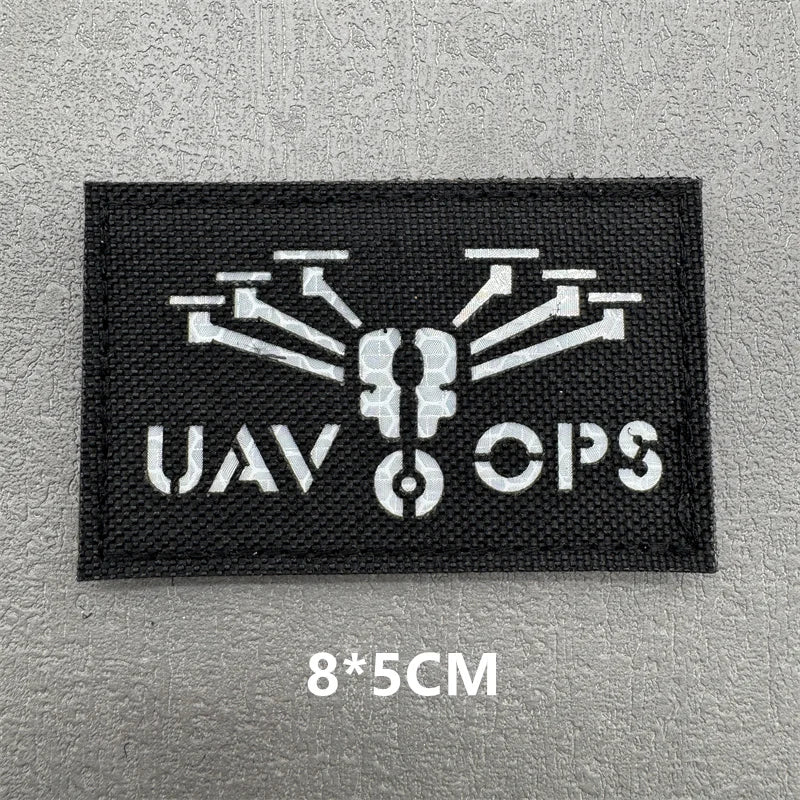 Black embroidered patch with white graphic featuring a stylized insect or gear design and the text UAV OPS