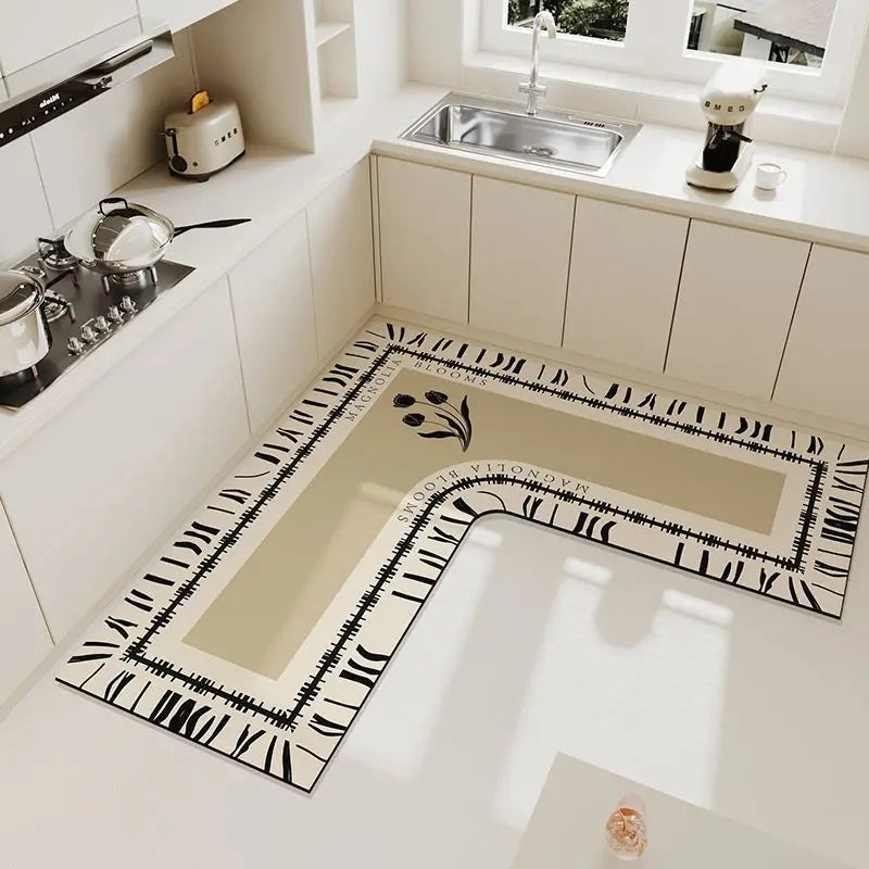 An L-shaped crystal velvet kitchen mat with a black and white patterned border is displayed on a white countertop.