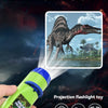 A hand holds a green projection flashlight toy showing a dinosaur silhouette and light beam.