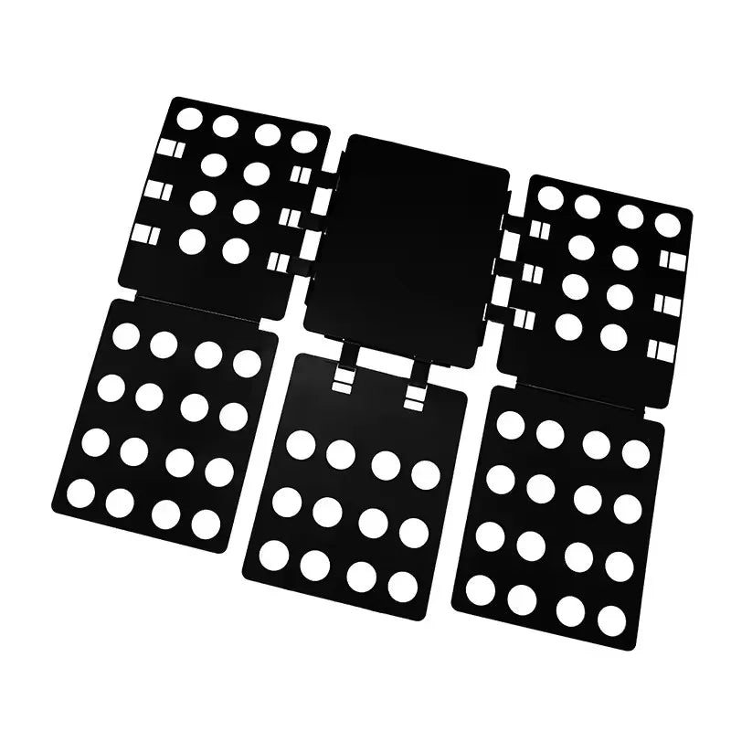 A black magic clothes folding board with multiple square and rectangular compartments for organizing t-shirts.