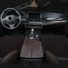 Interior view of a car showing a steering wheel, dashboard, and front seats covered with dark brown leather and patterned fab