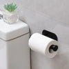 A white roll of toilet paper is mounted on a stainless steel self-adhesive holder next to a small potted succulent.