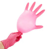 A hand wearing a pink disposable nitrile glove is shown holding another pink glove.