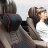 A close-up of a brown car seat headrest with a black memory foam pillow providing neck support for a woman.