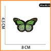 Five embroidered butterfly iron-on patches with yellow accents on a white background.