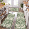 A rectangular green and cream patterned kitchen rug placed on a wooden floor.