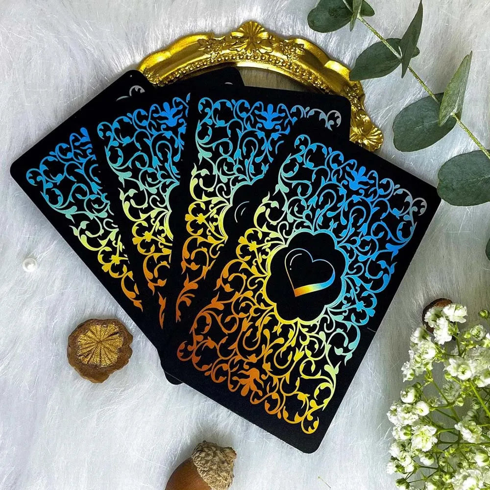 A black oracle card featuring a vibrant blue and gold floral design with a heart symbol on a white background.