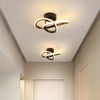 Modern clover-shaped LED ceiling light fixture with a gold and black design mounted on a white ceiling.