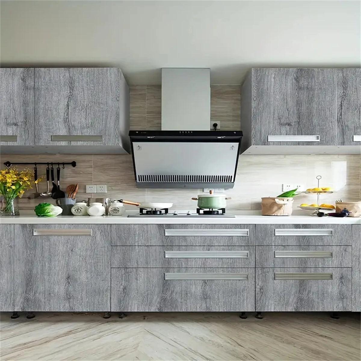 Modern kitchen cabinetry with gray wood grain panels and stainless steel appliances.