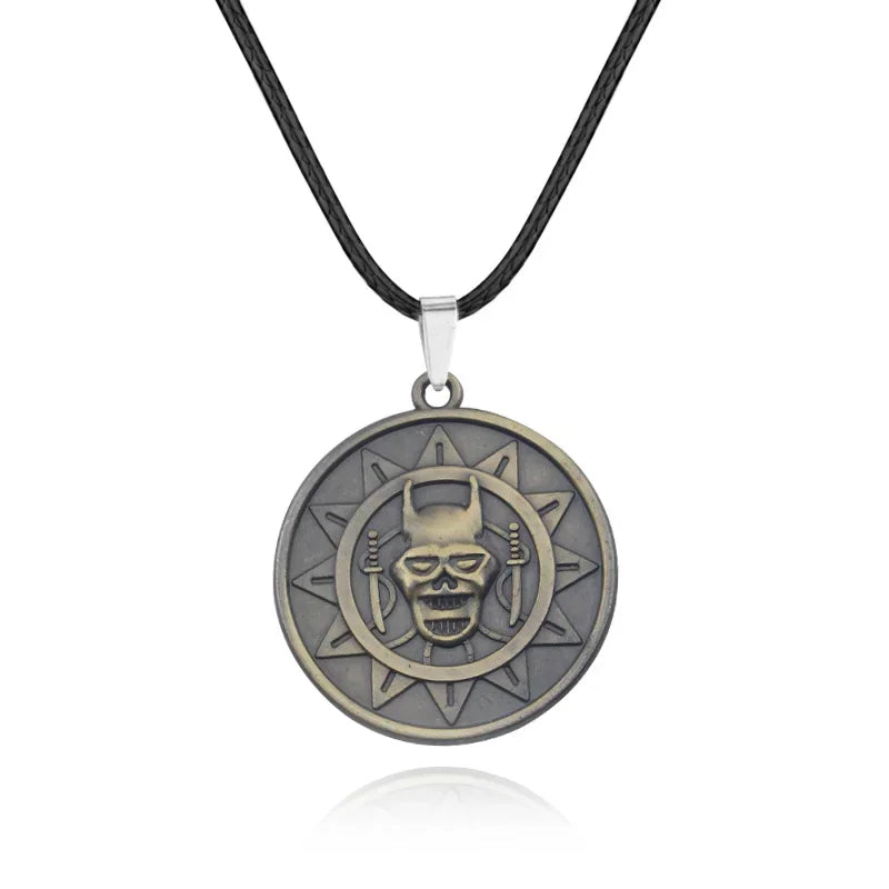 A silver pendant necklace featuring a detailed skull design within a circular, sun-like motif.