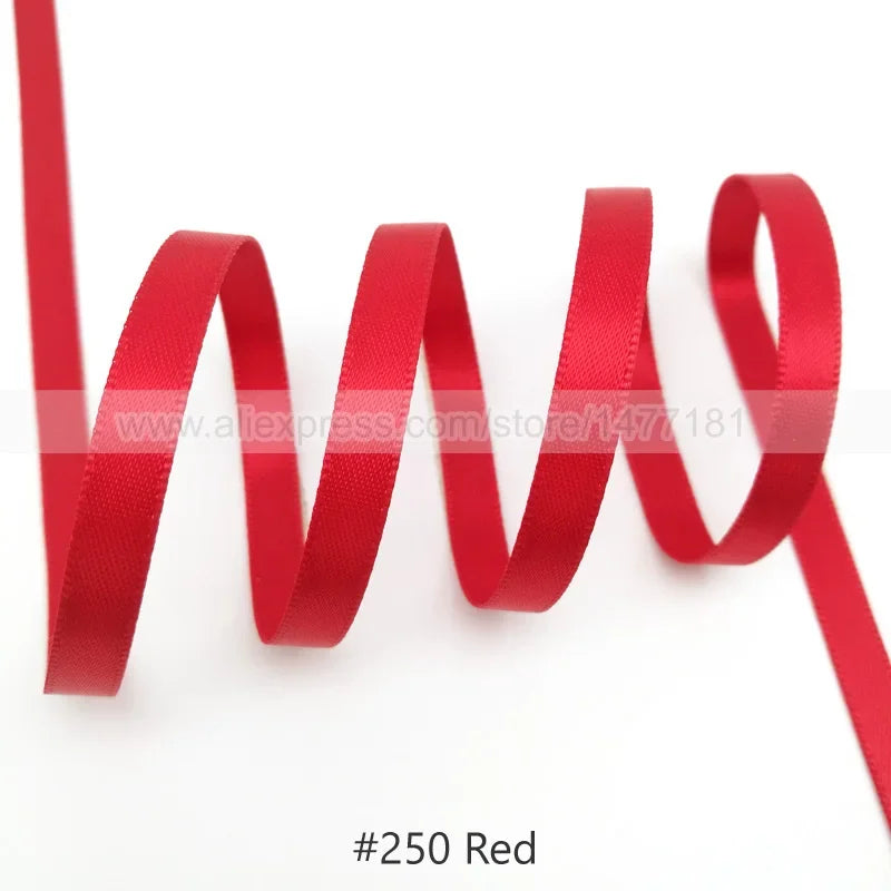 A red satin ribbon is shown in a wavy line against a white background.