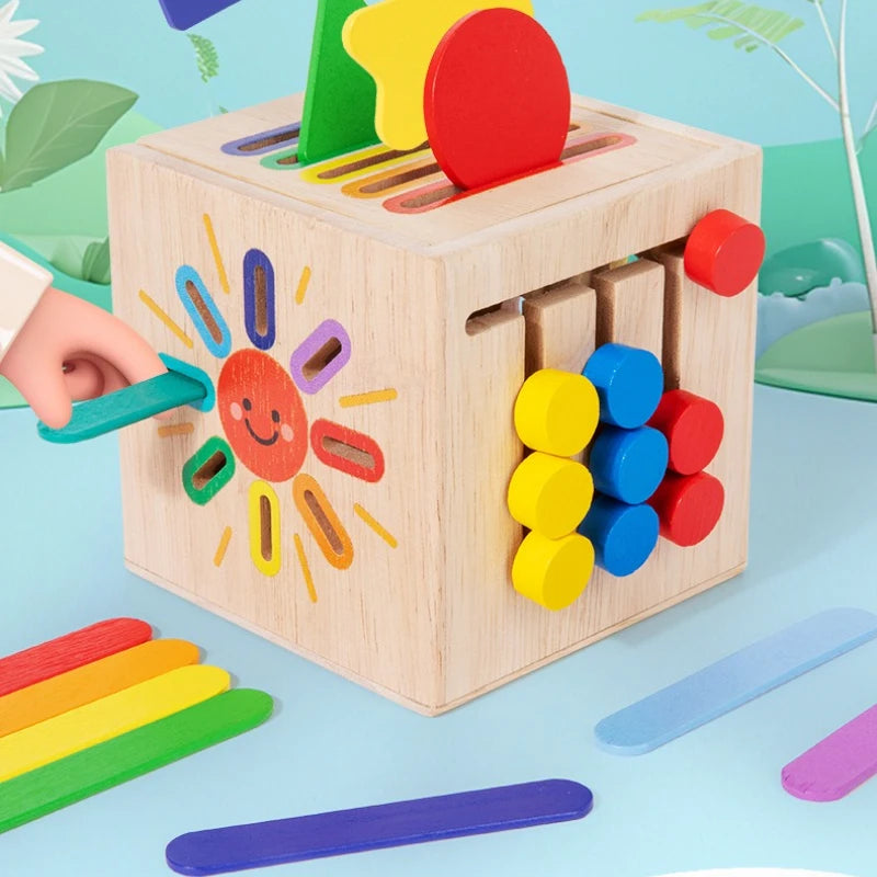 A wooden sorting toy box with colorful wooden shapes and colored sticks for toddlers.