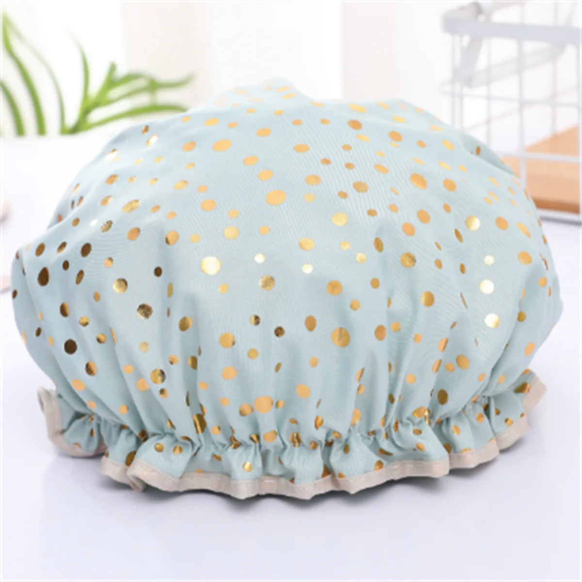 Light blue reusable elastic shower cap with gold polka dots