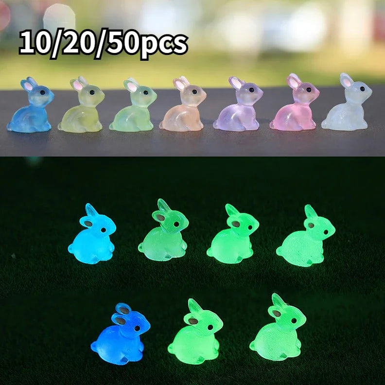 A set of ten resin miniature bunny figurines in various pastel colors arranged on a dark surface.