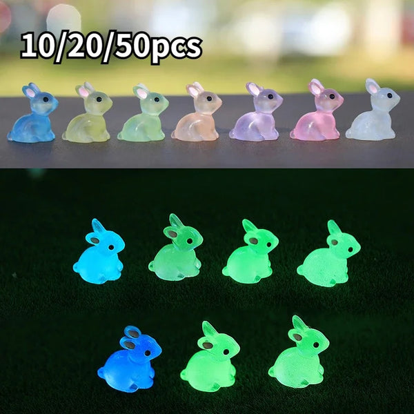 A set of ten resin miniature bunny figurines in various pastel colors arranged on a dark surface.