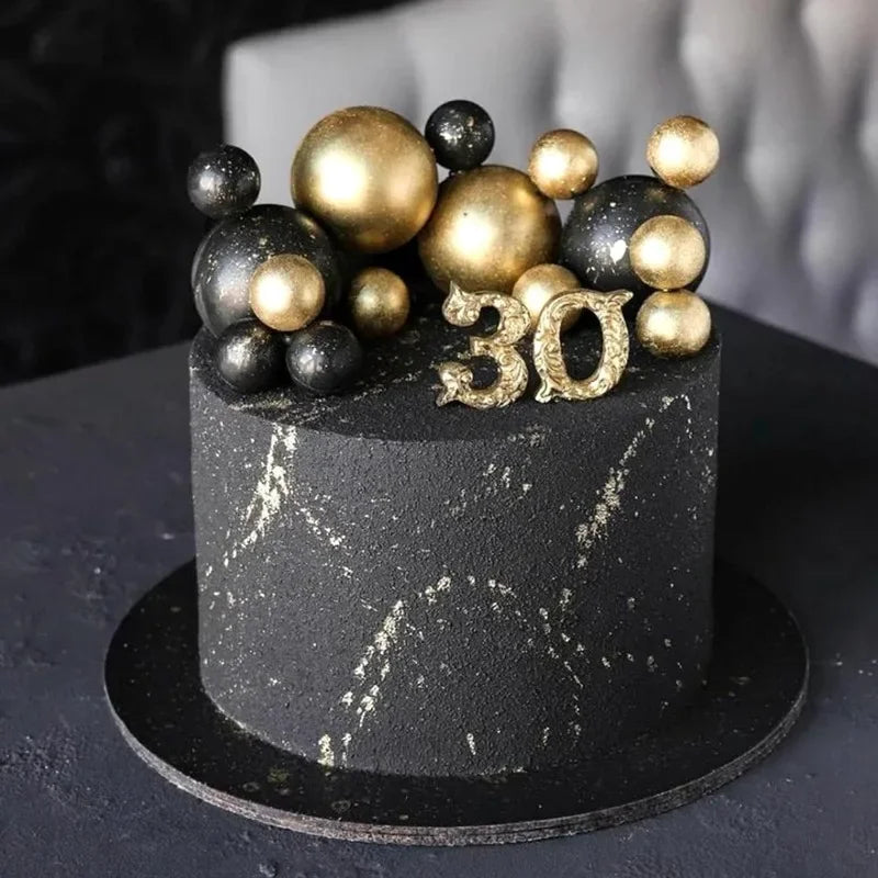 Schwarzer Kuchen mit goldenen und silbernen Kugeldekorationen für eine 30. Geburtstagsfeier.