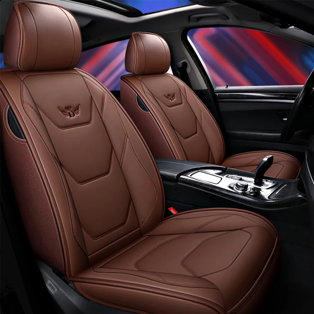Brown leather car seat covers with stitching and emblems shown inside a vehicle cabin.