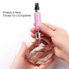 A hand is pressing a pink perfume spray bottle to complete the filling process.