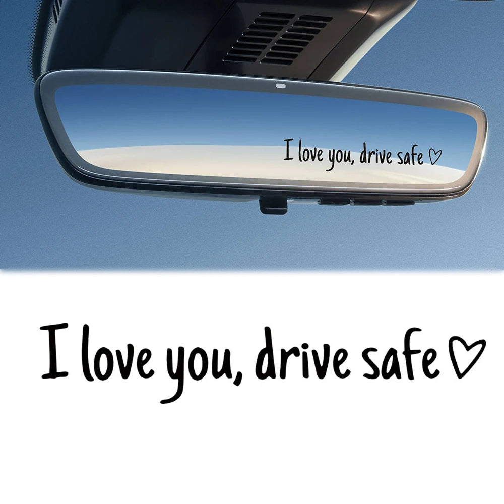 A car mirror with a message that reads I love you drive safe and a heart symbol.