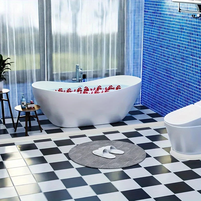 A modern white bathtub is set in a bathroom with blue tiled walls and a black and white checkered floor.