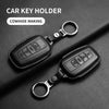 A black leather car key holder with a metal ring, showing two versions of the key case cover.