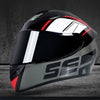 A black and silver full face motorcycle helmet with red accents shown against a dark background.